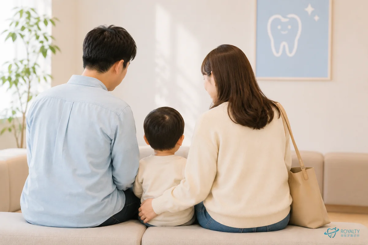 一家三口坐在牙醫診所候診區，孩子由父母陪同準備第一次看牙
